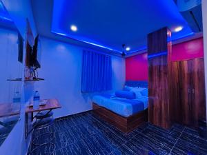 a room with a bed in a room with purple lights at Hotel Welcome Airoli in Navi Mumbai