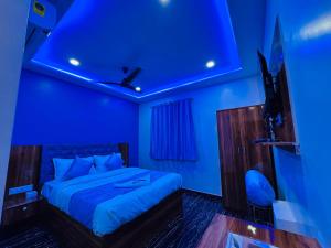 a blue bedroom with a bed with a blue ceiling at Hotel Welcome Airoli in Navi Mumbai +2 photos