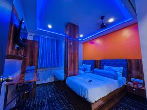 a bedroom with a bed with blue lights on it at Hotel Welcome Airoli in Navi Mumbai