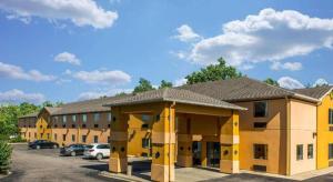 a large yellow building with cars parked in a parking lot at Suburban Studios Mason Hwy 42 in Mason