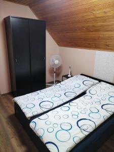 a bed in a room with a black cabinet at Bonita Apartman in Balatonberény