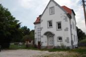 een groot wit huis bovenop een veld bij Kleines Schlösschen in Leinau