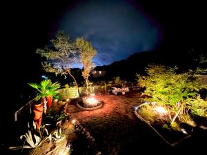 a garden at night with a fire pit and trees at スターハウス in Otsu
