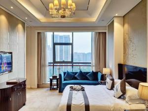 a bedroom with a blue bed and a large window at Hangzhou Huachen Fengting Hotel in Hangzhou