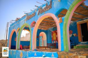 a blue building with arches in front of it at Heissa Nubian Hostel in Aswân Reservoir Colony