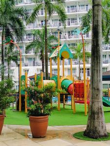 une aire de jeux en face d'un grand bâtiment dans l'établissement Shell Residences Mall of Asia by Jhem, à Manille