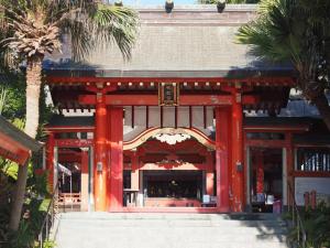 a red temple with a building with palm trees at GUEST HOUSE aoshima tei - Vacation STAY 42002v in Miyazaki