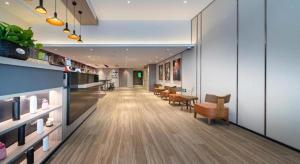 a long hallway with a table and chairs in a building at Hi Inn Shanghai Zhongshan Park Branch in Shanghai