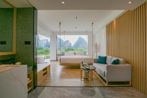 a bedroom with a bed and a couch and a table at 桂林阳朔良宿 LS Hotel Liangsu Yangshuo in Gaotian