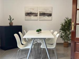 a white dining room table with white chairs at Triplex el Galeon in Adeje