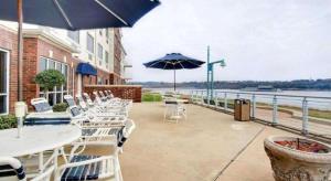 VidaliaにあるClarion Suites Vidalia Riverfrontのテーブルと椅子と傘のあるパティオ