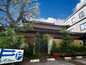 a house with a sign in front of it at Suigetsurou Hotel in Tonami