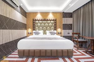 a bedroom with a large bed and a desk at Hotel Shady Oaks by Stay Pattern in Srinagar