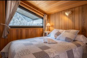 a bedroom with a bed with a large window at Beautiful apartment with superb view of Mont Blanc in Chamonix-Mont-Blanc