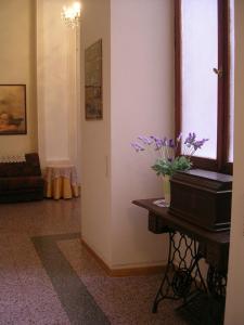 una habitación con una mesa con un jarrón de flores púrpuras. en Ascoli Antica B&B, en Ascoli Piceno