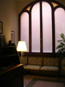 a living room with a couch in front of two large windows at Ascoli Antica B&B in Ascoli Piceno
