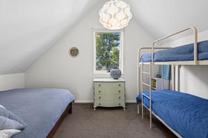 a bedroom with two bunk beds and a window at Point Roadknight Paradise Villa 6 - BYO Linen in Anglesea