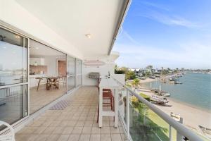 a balcony with a view of the ocean at Serenity Waters Riverfront Retreat - Walk to Mooloolaba in Mooloolaba