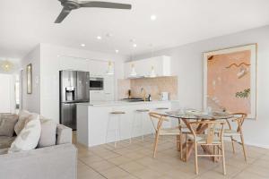 a kitchen and dining room with a table and chairs at Serenity Waters Riverfront Retreat - Walk to Mooloolaba in Mooloolaba