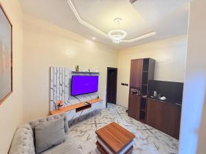 un salon avec un canapé et une télévision à écran plat dans l'établissement LaVintage Apartelle, à Lagos 5 autres photos