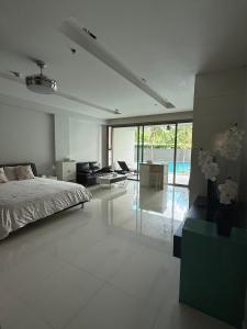 Un dormitorio con una cama y una sala de estar. en Beachfront condominium - Pattaya, en Norte de Pattaya