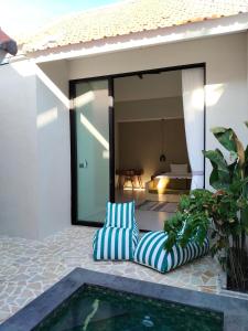 een stoel op een patio naast een zwembad bij One bed room - 5 minutes to beach and cafe in Denpasar