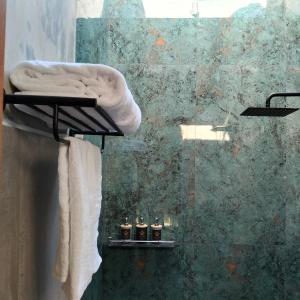 een badkamer met een handdoek en drie kaarsen op een plankje bij One bed room - 5 minutes to beach and cafe in Denpasar