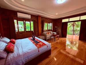 a bedroom with a bed and a living room at Baantientong in Krabi town