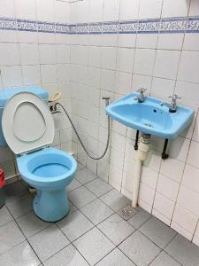 a bathroom with a blue toilet and a sink at Mega Inn Sri Aman in Sri Aman