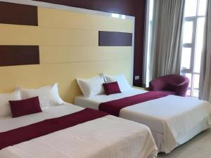 a hotel room with two beds and a chair at LF Hotel Tapah in Kelian Baharu +83 photos