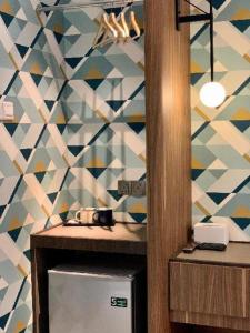 a kitchen with a tile wall with a sink and a refrigerator at Airdence in Kampong Sembulan +110 photos