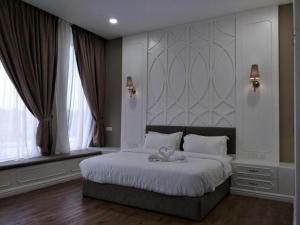a bedroom with a large bed with a large headboard at M GLOBAL HOTEL in Kampong Jeram +49 photos
