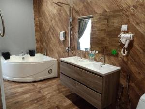 une salle de bain avec une baignoire et un lavabo et une baignoire dans l'établissement M GLOBAL HOTEL, à Kampong Jeram 110 autres photos