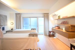 a hotel room with two beds and a window at Yolo Hotel in Tokyo