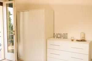 a white cabinet with a home sign on top of it at Apartment Di Lago Family by GardaDoma in Brenzone sul Garda +20 photos