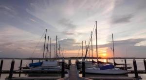 a group of boats docked at a dock with the sunset at S Bee Hotel in Johor Bahru