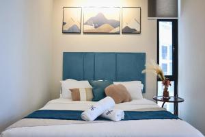 a bedroom with a blue and white bed with pillows at Homesuite' Home at The Shore in Kota Kinabalu