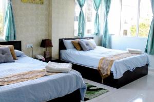 two beds in a bedroom with blue drapes at Hotel Darulaman Alor Setar in Alor Setar +40 photos