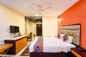 a bedroom with a bed and a desk and a television at FabHotel Bagatel in Calangute +27 photos