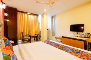 a hotel room with a bed and a desk at FabHotel Bagatel in Calangute