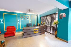 an office with a red chair and a blue wall at FabHotel Bagatel in Calangute