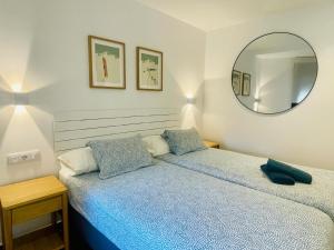 a bedroom with a blue bed and a mirror at Apartamentos San Nicolas Jaca in Jaca