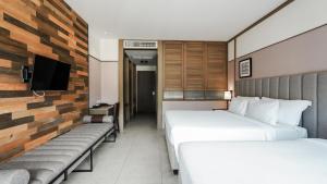 une chambre d'hôtel avec deux lits et une télévision dans l'établissement Sugar Marina Hotel CLIFFHANGER Aonang, à Ao Nang Beach
