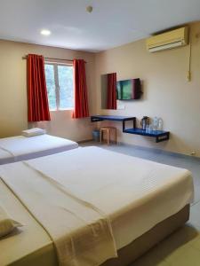 a bedroom with two large beds in a room at Hotel Jelai Kuala Lipis (Jln Bk Bius) in Kuala Lipis