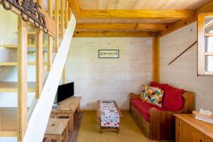 een woonkamer met een rode bank in een houten huis bij goitik ikusita in Aïnhoa