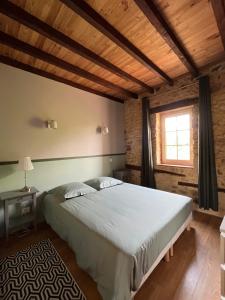 a bedroom with a large bed and a window at Gîtes OSTAL de Marcillac avec piscine - Petit Bois in Capelou