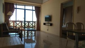 a living room with a television and a table and chairs at OYO Home 90533 Nomadic Town Condo in Melaka