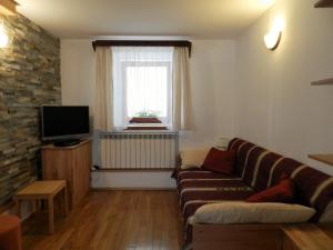 a living room with a couch and a television at Apartment Kenda in Bovec