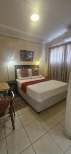 a bedroom with a large bed in a room at Boiketlo Lodge Gaborone in Gaborone