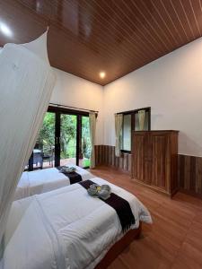 a bedroom with two beds and a large window at Khrisna Hs and Cottages in Sidemen +259 photos